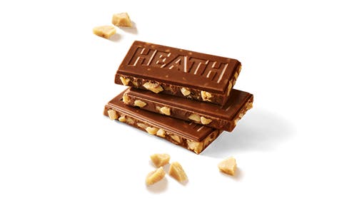 unwrapped pieces of a heath english toffee bar beside piles of toffee bits