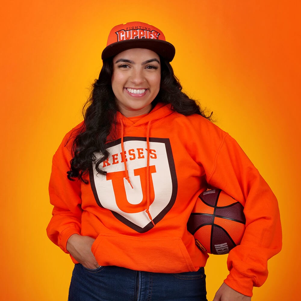 woman wearing reeses university branded clothing holding a basketball