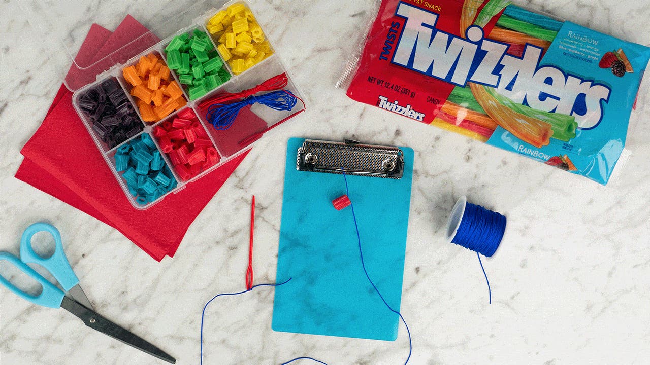 threading the jewelry cord with cut up rainbow candy pieces