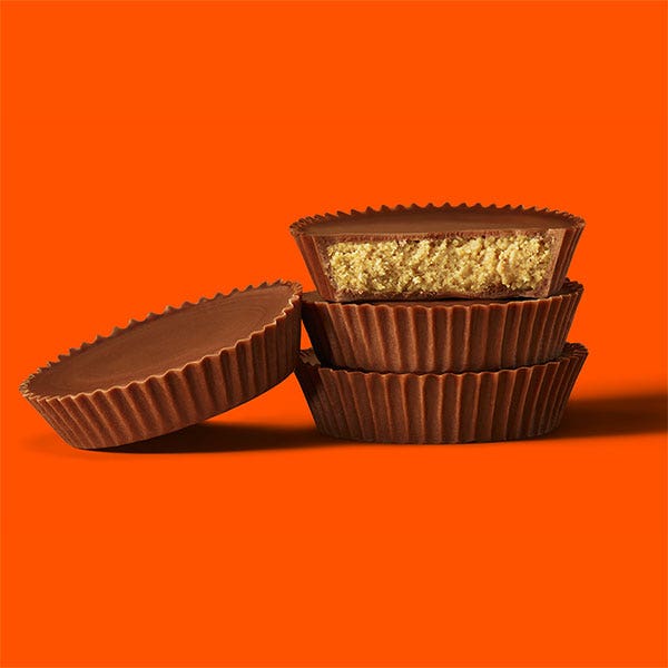 stack of unwrapped reeses milk chocolate peanut butter cups