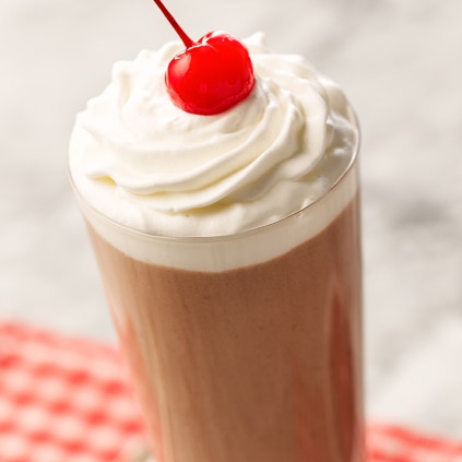 chocolate milkshake with whipped cream and a cherry
