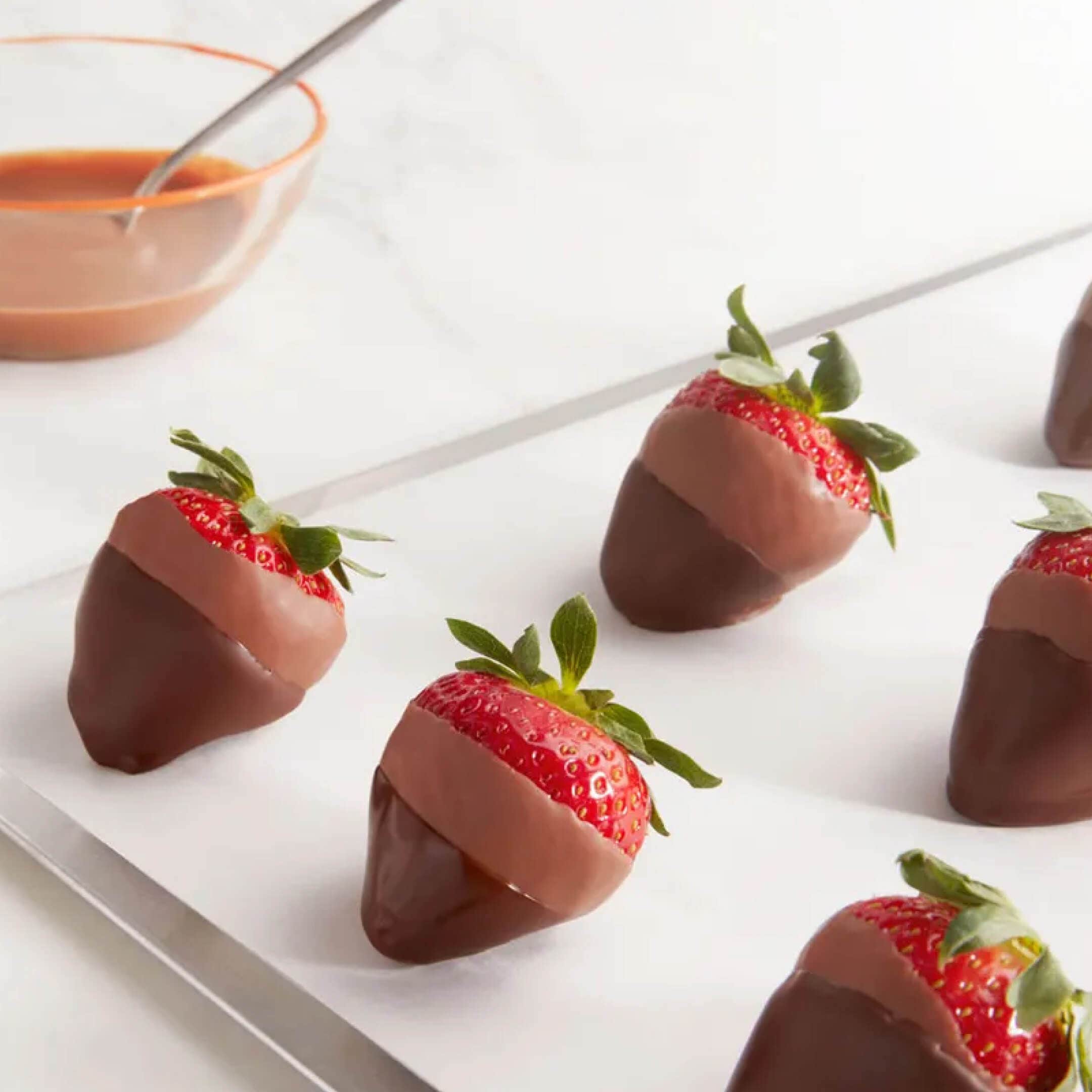 tray of strawberries dipped in milk chocolate and then dipped in dark chocolate
