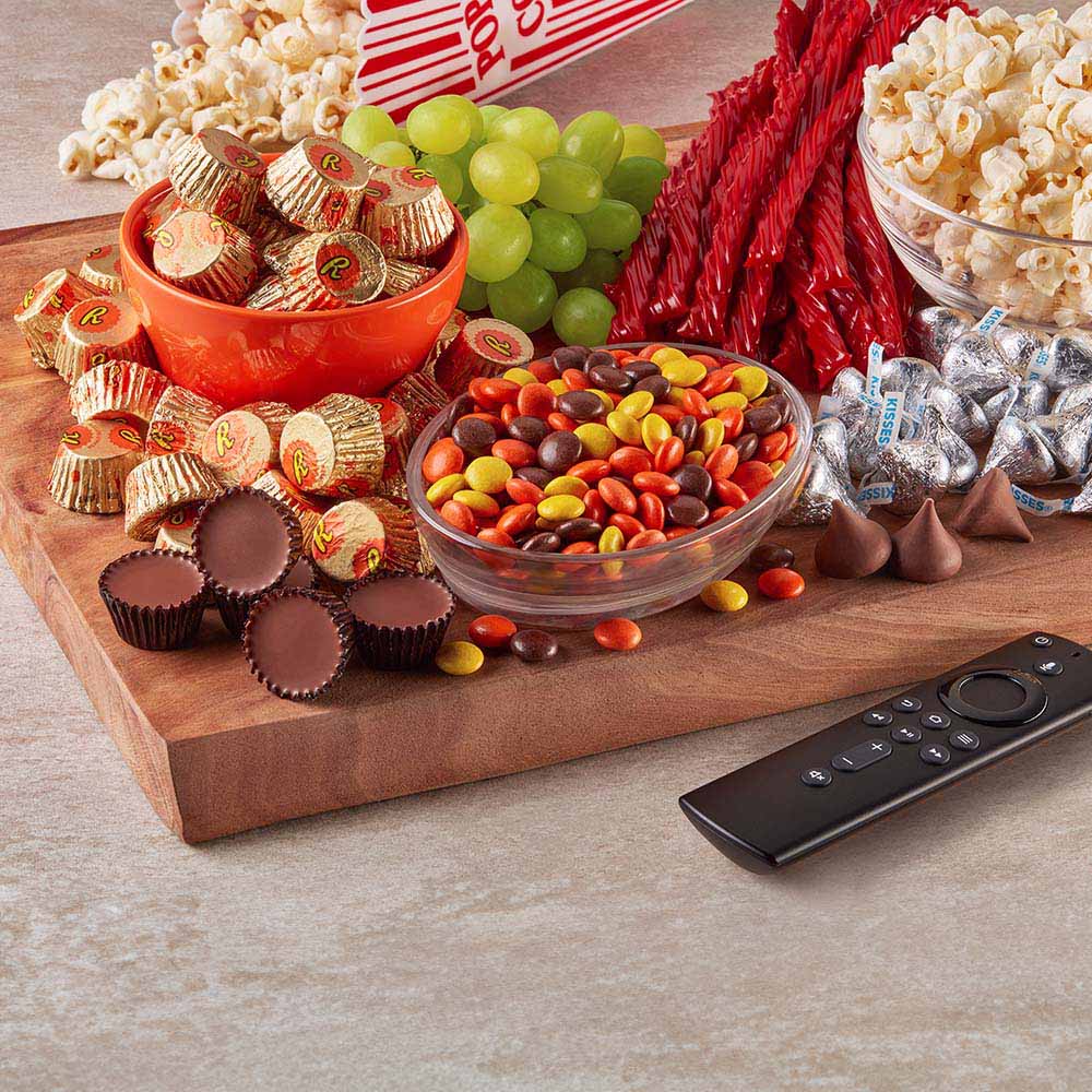 snack board piled high with assorted hersheys candy and salty snacks