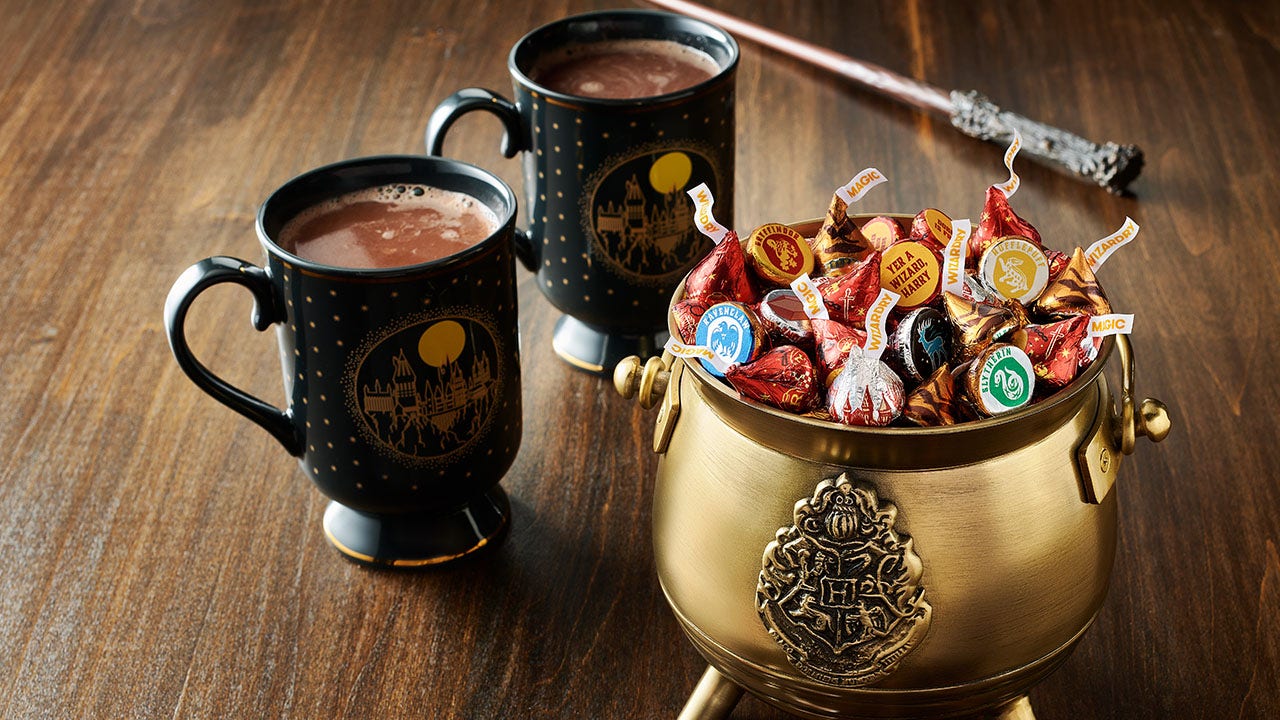 cauldron full of harry potter hershey kisses beside two mugs of hot cocoa