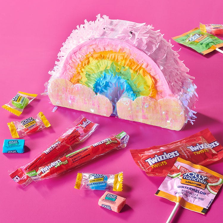 rainbow cloud pinata surrounded by assorted hersheys candy