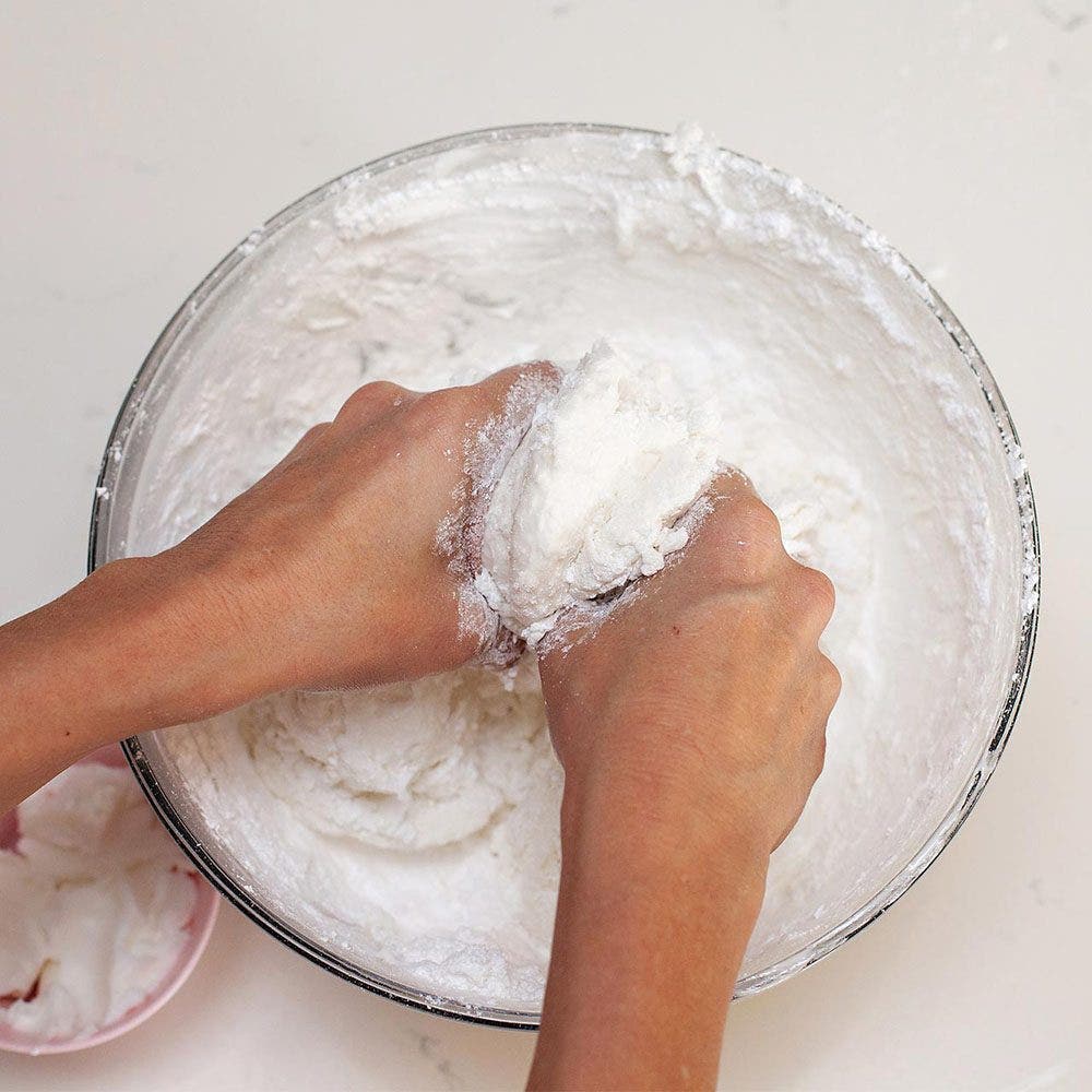 person mixing ingredients creating marshmallow fondant